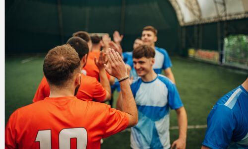 Two teams lined up clapping hands after a game.